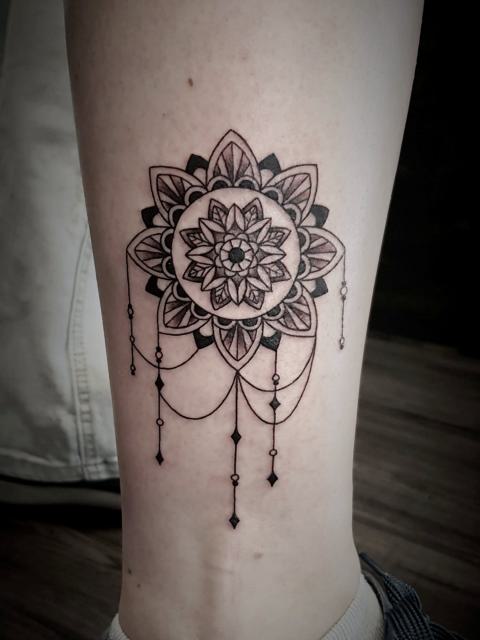 Geometrikus mandala csüngő elemekkel a lábszáron