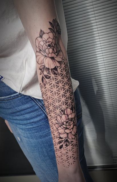 Geometrikus mandala virágokkal az alkaron és a kézháton