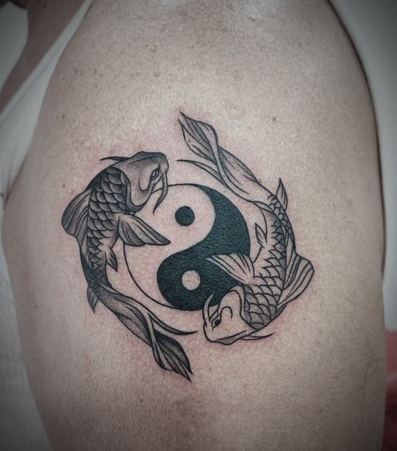 Szürke-fekete árnyalt yin-yang koi halakkal a felkaron